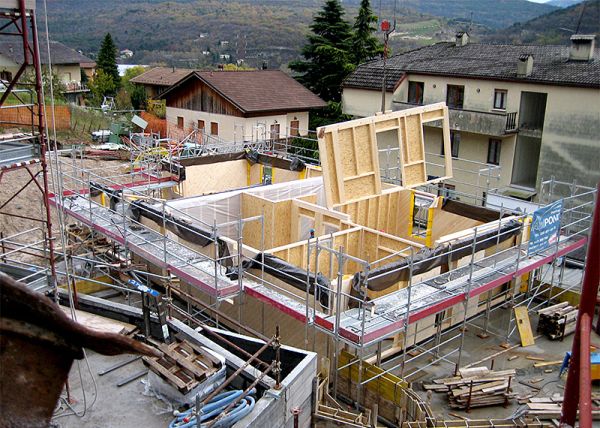 Costruzione di un edificio in legno, con sistema Platform Frame. Nell’immagine si vede la posa di pareti in parte prefabbricate ed assemblate poi in cantiere. Fonte: Nordhaus 