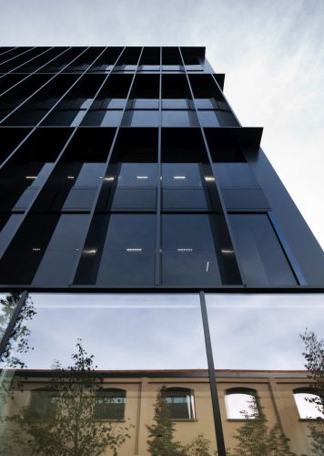 Gucci Hub, la facciata in vetro scandita da una trama di brisoleil in metallo scuro.