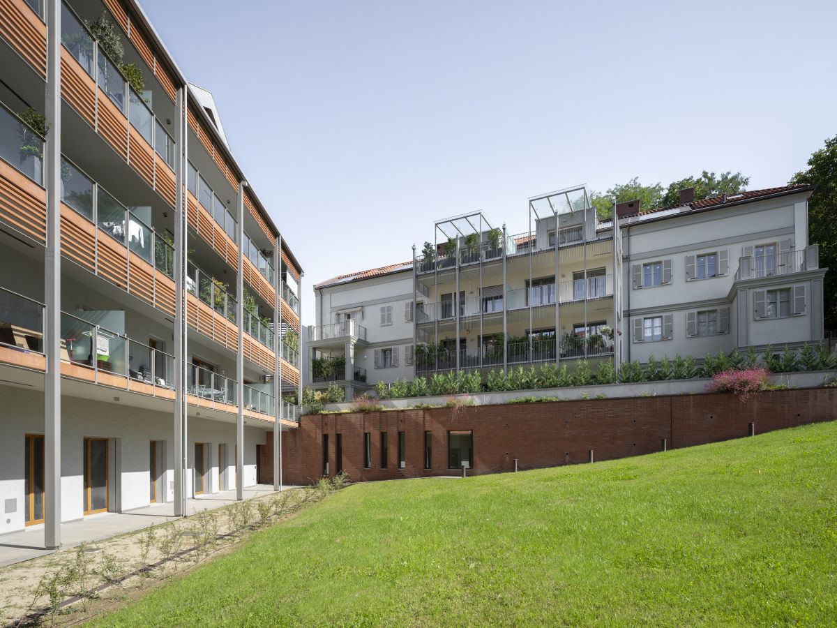 Il complesso residenziale Borgo Hermada delinea una delicata transizione tra città e collina.