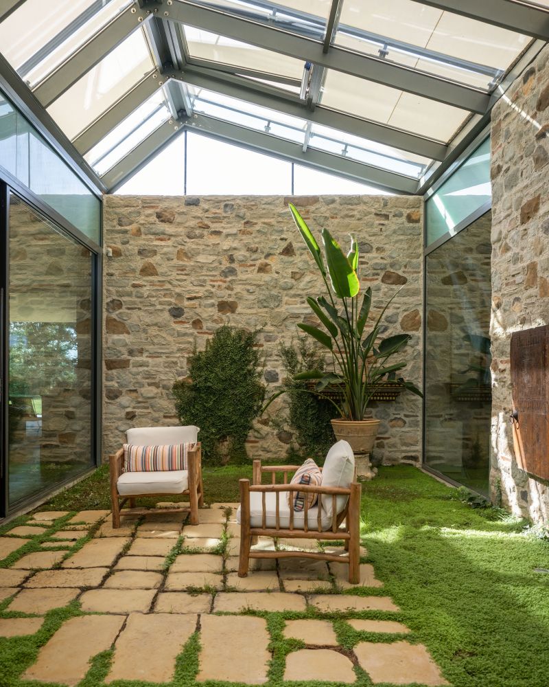 La pavimentazione mista di pietra naturale e verde del volume centrale della Casa a patio La pavimentazione mista di pietra naturale e verde del volume centrale della Casa a patio